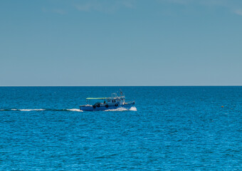 A Small Boat Sailing on the Blue Beach of Mahdia, Tunisia. North Africa