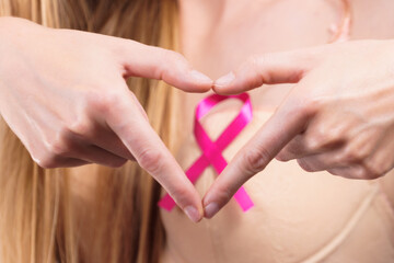 Woman with pink cancer ribbon on breast