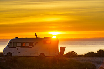 Caravan on sea at sunrise.