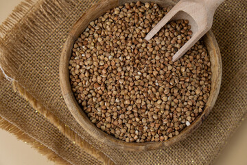 Raw buckwheat porridge in neutral beige background copy space. Whole spelt grain species. High protein fiber-rich vegan plant based food ingredient. Gluten free superfood healthy nutritional dietary
