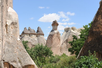 Limestone rock formations (Fairy Chimneys) with blue sky and white clouds in Paşabağ Valley called the Valley of the Priests near Göreme, Anatolia, Cappadocia, Turkey (Türkiye)
