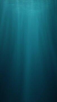 Vertical slow-motion footage of underwater god rays piercing the ocean surface, with enchanting beams of light flickering. Ideal VFX background for diving, snorkeling, and summer adventures
