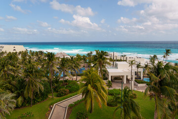 Enjoy the stunning beach view with palm trees and crystal waters under a bright sky