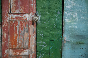 Rustic weathered door with red paint peeling reveals vintage charm