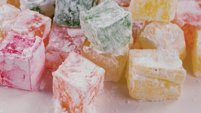 Turkish delight candies in vibrant colors, on a white surface. Slider shot. Details of the powdered sugar coating and colorful interiors. Turkish Culture, Festive Treats, Traditional Sweets, Desserts.