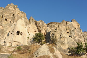Rock formations with caves on a sunny day in Cappadocia, Anatolia,  eastern Turkey