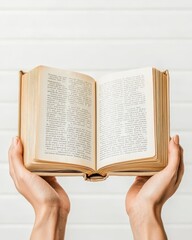 A close-up of hands holding an open book, symbolizing knowledge, learning, and the joy of reading.
