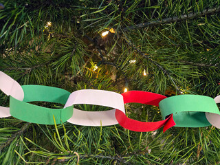 Close-up of a homemade Christmas paper chain on a green pine tree