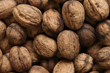 Heap of walnuts in shell, close-up, top view. Healthy eating. Harvest, agriculture. Walnuts, selective focus, background