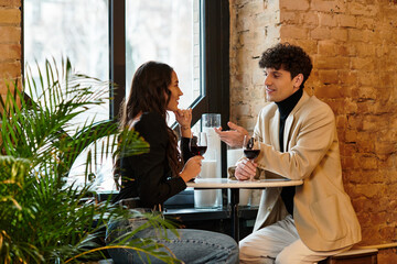 Two lovers celebrate their special day with wine and conversation in a charming venue.
