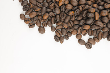 Roasted coffee beans scattered on a white background.  Perfect for coffee-themed designs and branding.