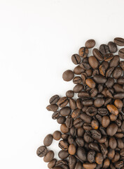 Roasted coffee beans scattered on a white background. Rich brown tones and natural textures.