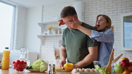 Happy family preparing vegetables in kitchen closeup. Wife closing eyes husband