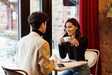 A happy couple enjoys each other's company while celebrating Valentines Day in a romantic setting.