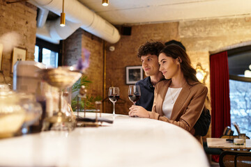 A young couple shares a cozy dinner, savoring wine and each others company.