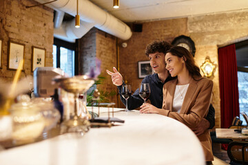 A young couple enjoys each other’s company while toasting with wine, celebrating love.