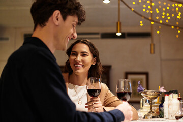 Romantic evening at a cozy restaurant where a couple smiles while enjoying each others company.