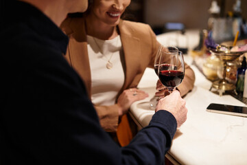 Young couple enjoys a romantic evening together, toasting with red wine in a charming restaurant.