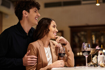 A young couple enjoys a romantic evening together in a charming restaurant, celebrating their love.
