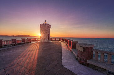 Sunset view of Piombino piazza Bovio lighthouse and Elba Island. Tuscany, Italy