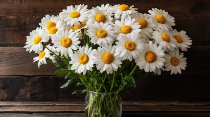 Obraz premium Vibrant daisy bouquet in glass vase against rustic dark wood background showcasing natural beauty and floral elegance