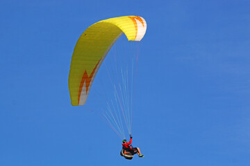 Paraglider flying in a blue sky
