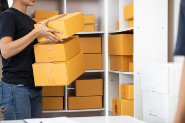 Fototapeta premium Start Up entrepreneurs who are running SME businesses are preparing products in boxes and parcels to be ready for shipping to customers. Preparing products in box and parcels to be ready for shipping.