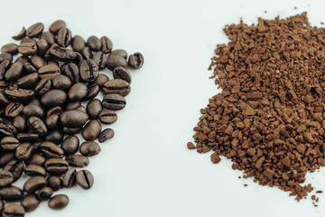Whole coffee beans and instant coffee granules side-by-side. A comparison of two popular coffee forms.