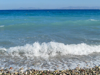 Waves crashing on a pebbled beach by the sea