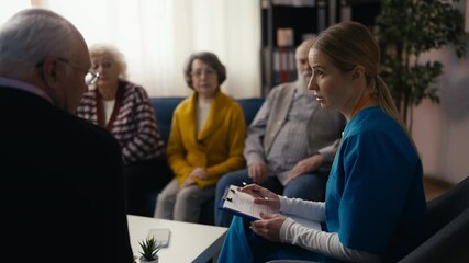 Doctor consults seniors in group therapy at a nursing home, providing care - Powered by Adobe