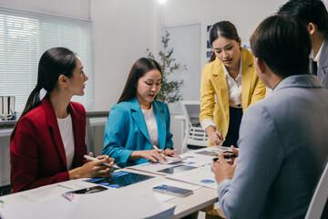 Asian businesspeople are discussing and brainstorming about new projects and analyzing financial reports, graphs and charts during a meeting in the office