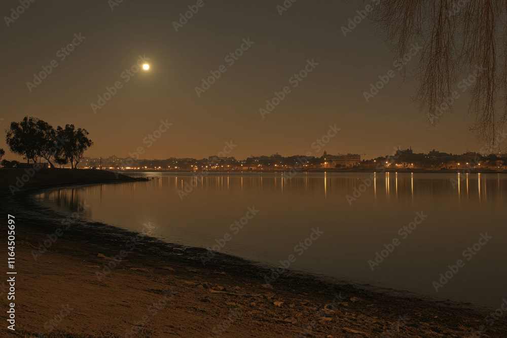 Wall mural A Serene Lake Reflecting The Moonlight And Stars During Ramadan Evenings