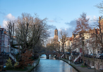 dom tower and blue sky reflected in water of canal in dutch city of utrecht