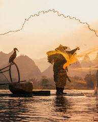 silhouette of a cormorant fisherman at sunsset