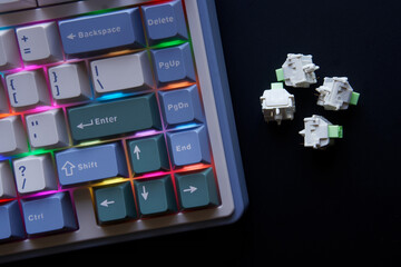 Mechanical keyboard switches next to wireless computer keyboard with multi-colored RGB backlight...