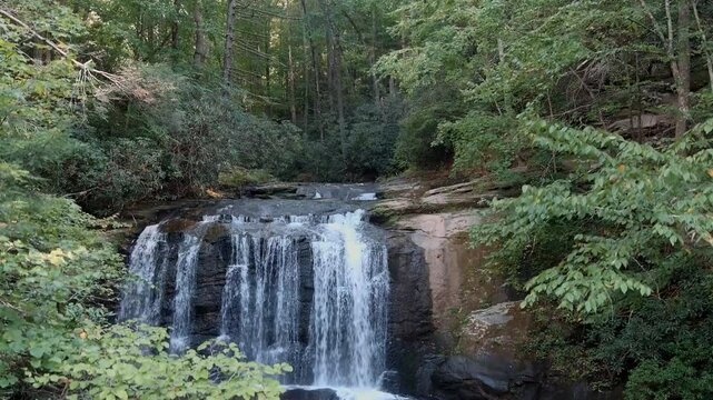 Descending drone shot of Little Bradley Falls, a waterfall in the mountains of North Carolina, USA.