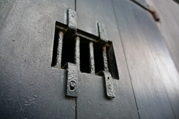 An old, black cell door in a prison which is called "The Hanoi-Hilton".