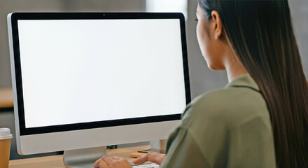 Shoulder to back view. young woman using computer at workplace close up view of white screen. mock up banner for website header design with copy space for text