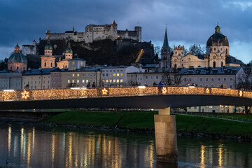 Makartsteg (love lock padlock bridge) over the Salzach River, with the fortress in background. Salzburg cityscape at night