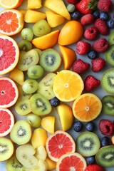 A colorful display of various fruits, including kiwi, oranges, and raspberries