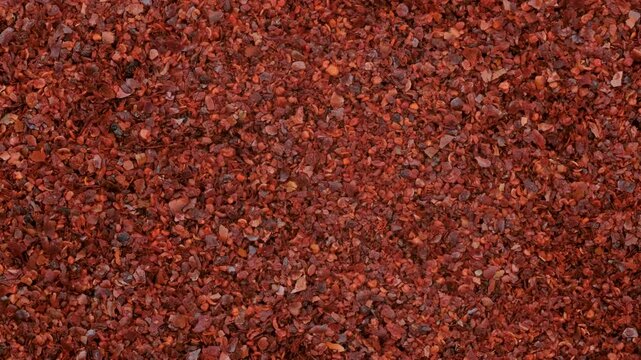 Top down view. Heap of red chili pepper flakes, slider shot. Ingredients, food seasoning, cooking, spices, flavor concepts. 4k