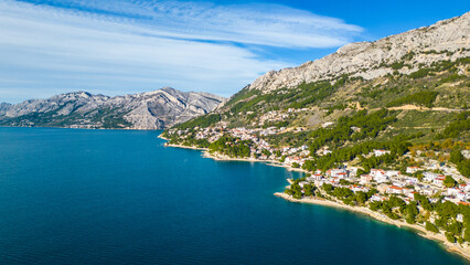 Obraz premium A stunning aerial view of Brela, Croatia, showcasing the iconic Kamen Brela rock formation surrounded by crystal-clear turquoise waters. The coastline is dotted with pristine beaches
