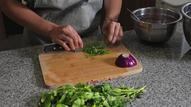 woman chopping tomato to prepare a guacamole typical of mexico 
