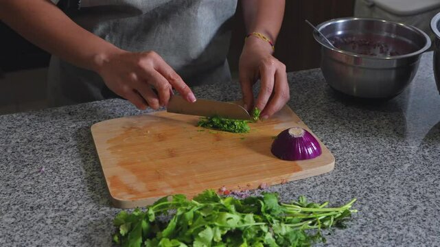 woman chopping tomato to prepare a guacamole typical of mexico cilantro