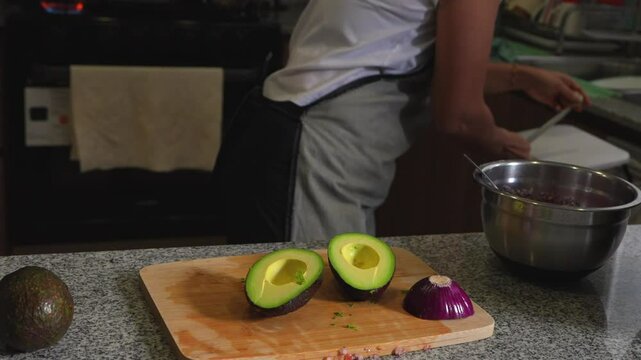 woman chopping tomato to prepare a guacamole typical of mexico avocado