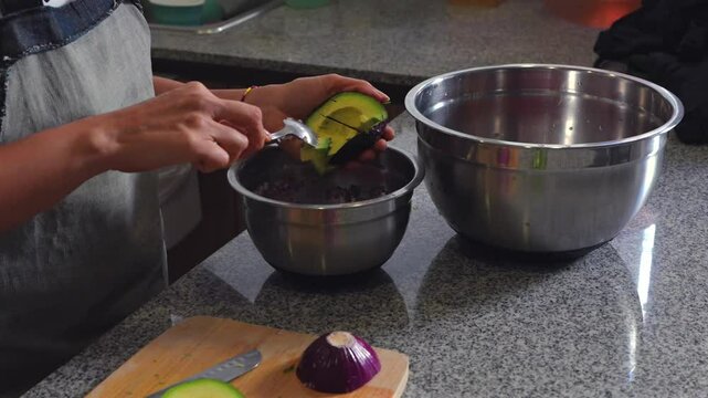 woman chopping tomato to prepare a guacamole typical of mexico avocado cubes