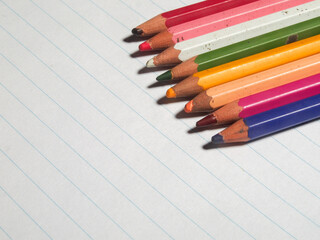 Fototapeta premium colored pencils on white lined paper.