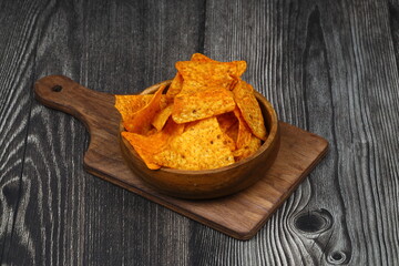 Nachos in a wooden bowl. Tortilla chips on wooden background.