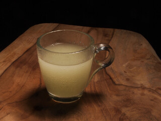 effervescent tablet in glass on wooden board with black background.