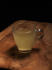 effervescent tablet in glass on wooden board with black background.